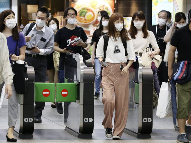 Mọi người đeo khẩu trang khi đi bộ tại ga Ofuna ở Yokohama, Nhật Bản. Ảnh: theguardian.com